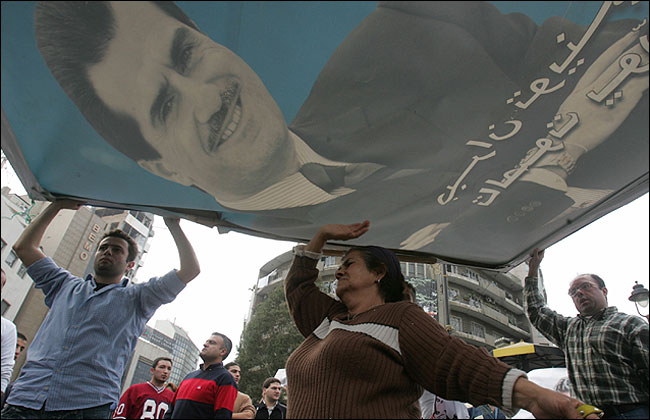 Lebanese mourn the death of Gebran Tueni, holding a huge poster bearing his picture, Beirut, December 12, 2005.